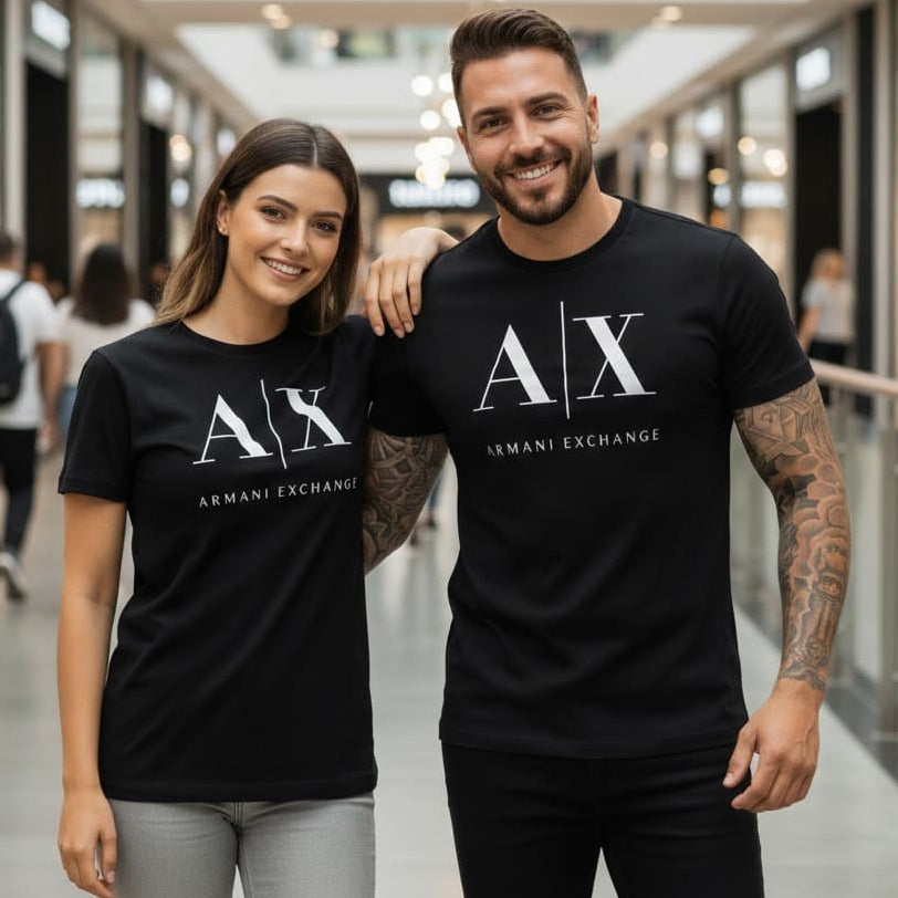 Усмихната двойка с черни тениски Armani Exchange в търговски център.