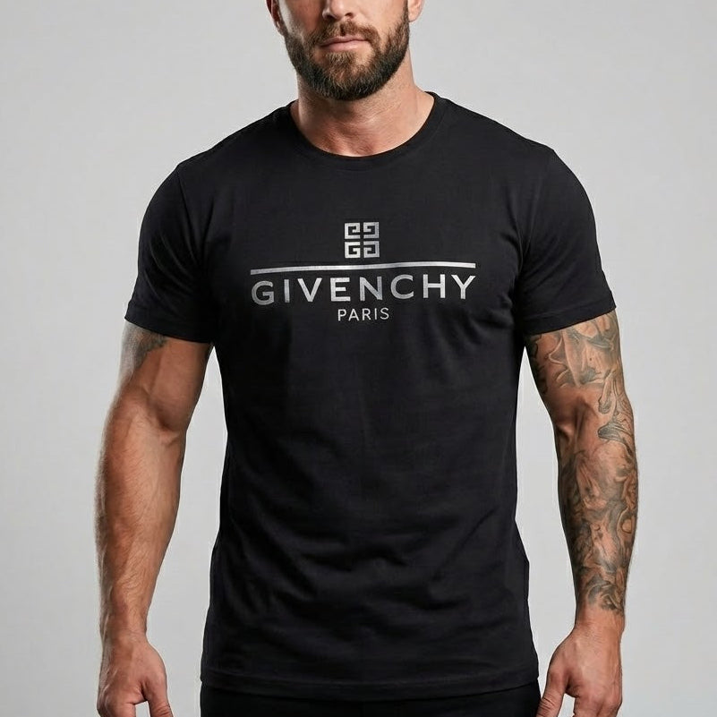 Мъж с татуировки позира с черна тениска Givenchy със сребристо метално лого в центъра.