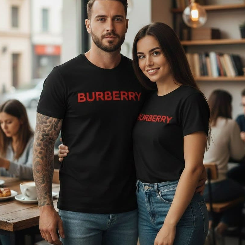 Мъж и жена в кафене, облечени в еднакви черни тениски с червен надпис Burberry.