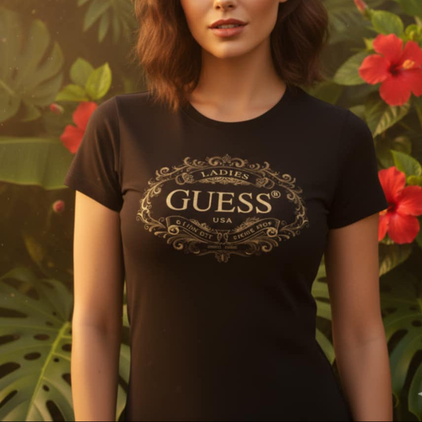 Дамска черна тениска GUESS със златисто орнаментно лого на фона на тропически цветя.