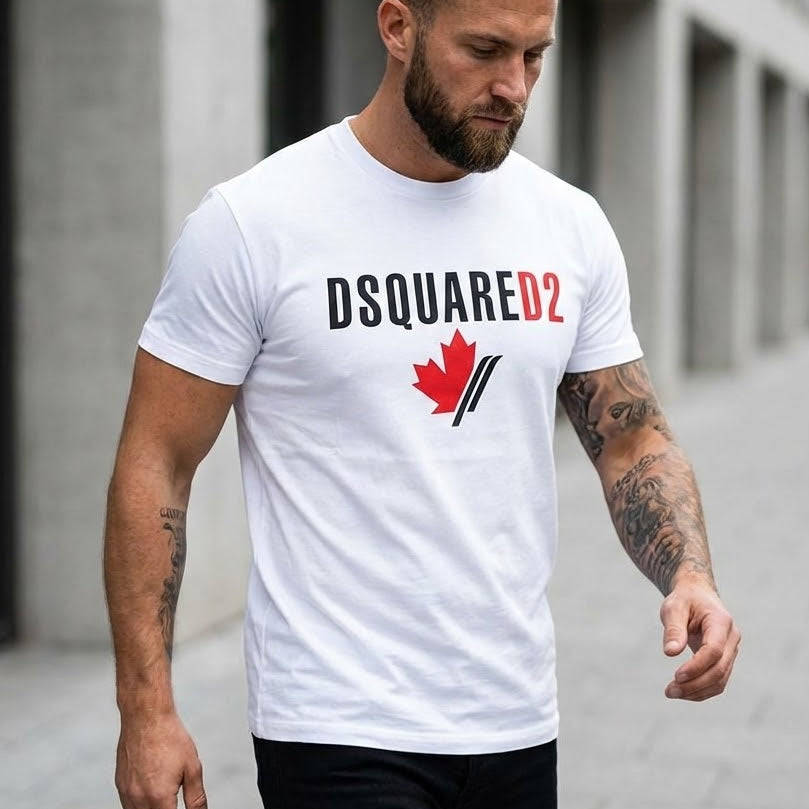 Мъж с бяла тениска Dsquared2 с черен надпис и графичен елемент червено канадско листо