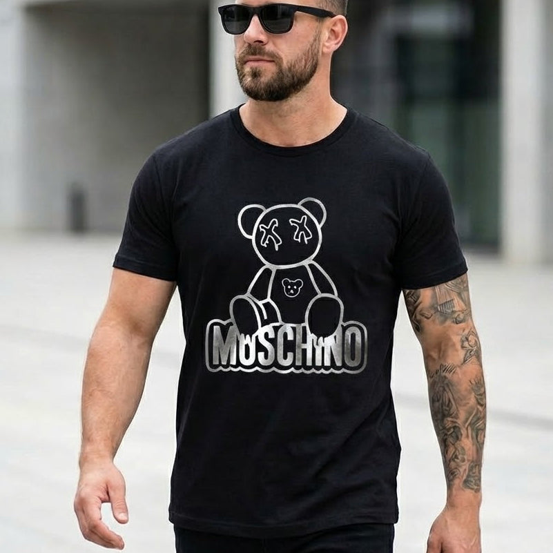 Мъж със слънчеви очила и черна тениска Moschino със сребристо лого на мече и надпис