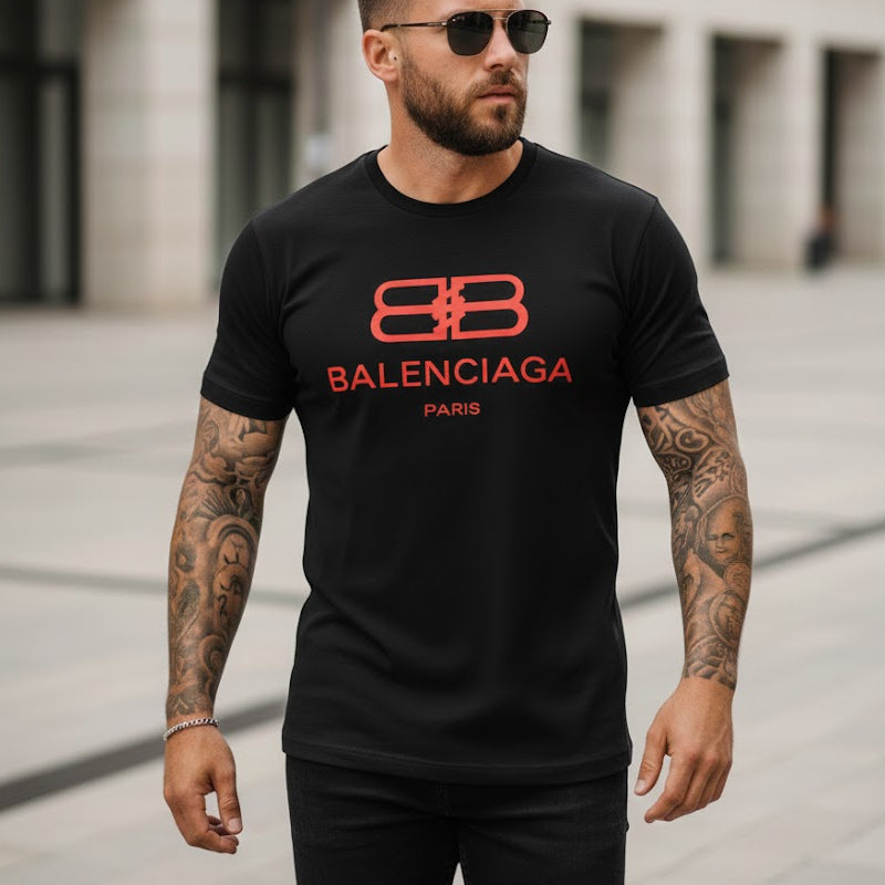 Мъж с татуировки носи черна маркова тениска с червено лого на Balenciaga