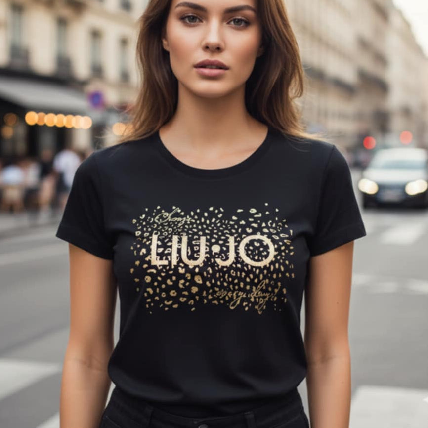 Дамска черна тениска Liu Jo със златно лого и леопардови мотиви, носена от модел на градски фон. 100% памук. Fashionvibe.eu