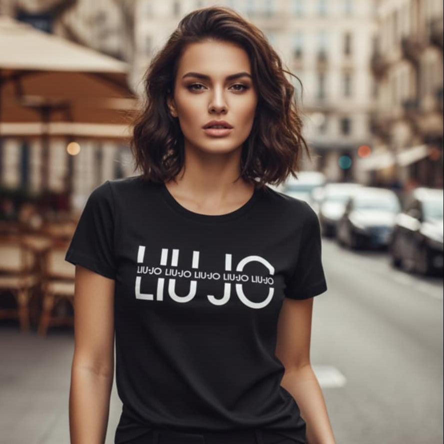 Млада жена с къса коса, носеща черна тениска Liu Jo с голям бял графичен надпис на уличен фон