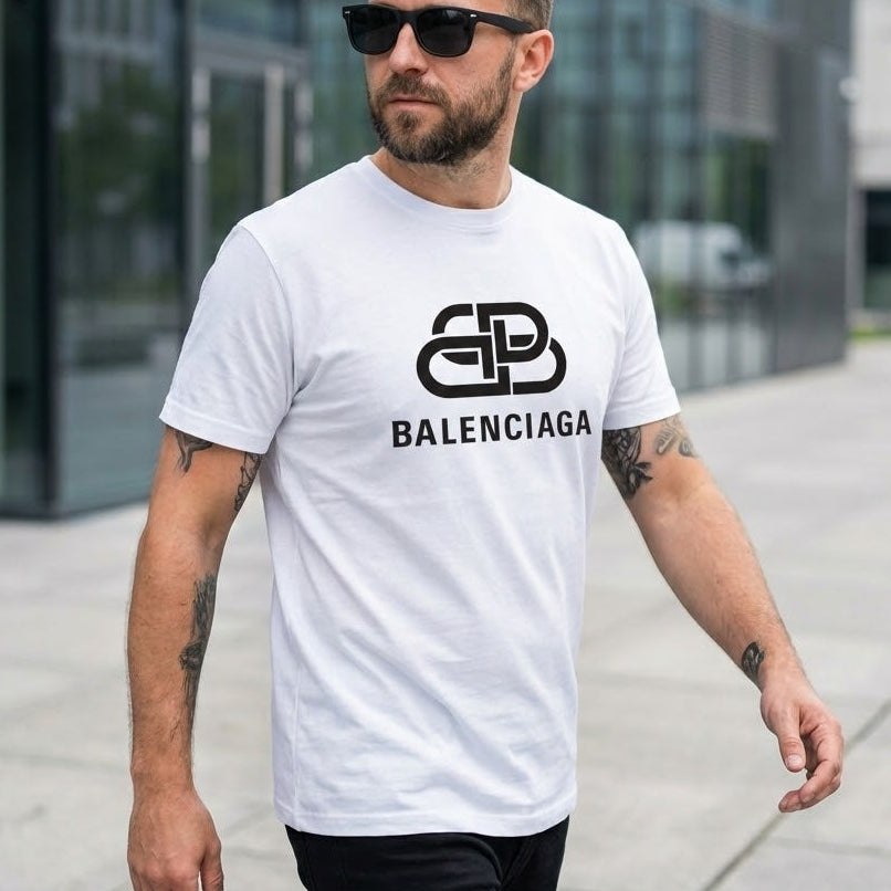 Мъж с бяла тениска Balenciaga с голямо черно лого с преплетени букви "B" на гърдите