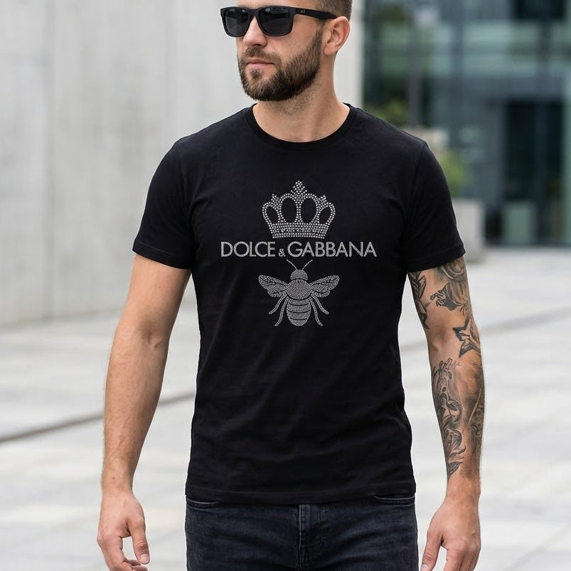 Мъж с черна тениска Dolce & Gabbana с блестяща корона и пчела на гърдите